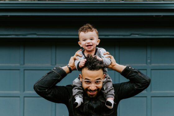 Photo of a dad holding his son over his shoulders