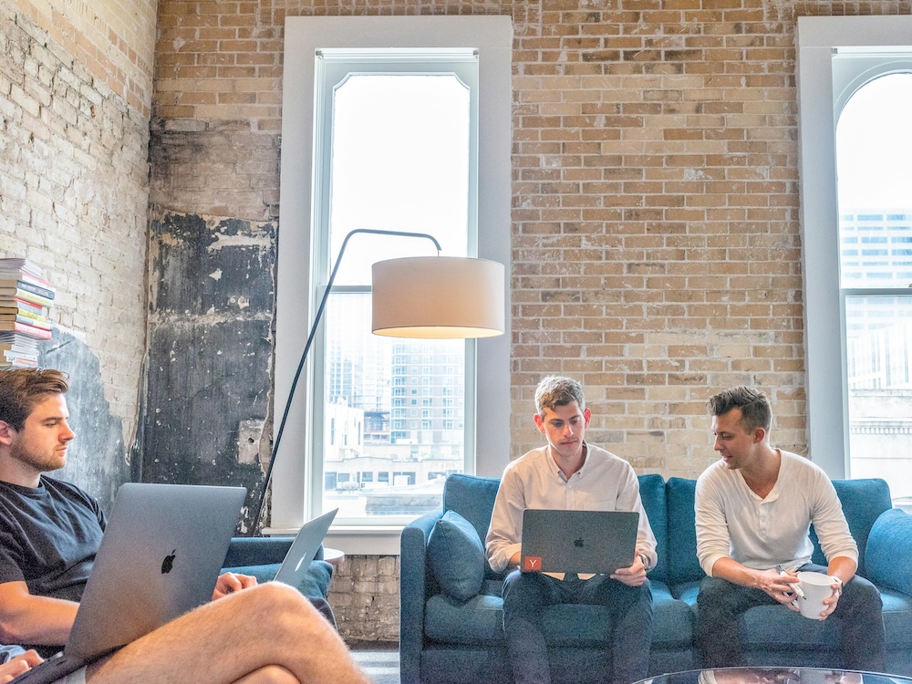 3 men using laptops on couches