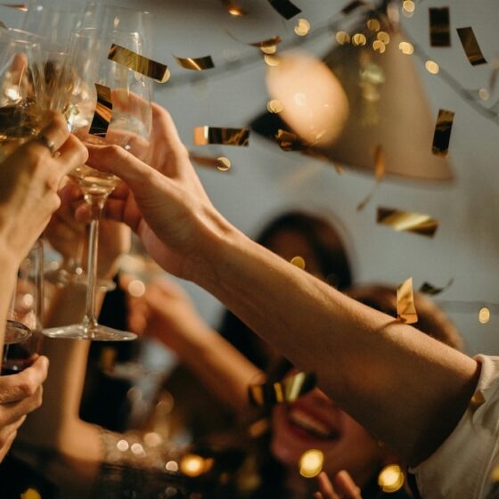 People celebrating and toasting wine glasses at a party