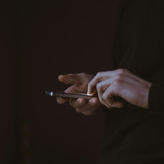 Man holding a cellphone in the dark.