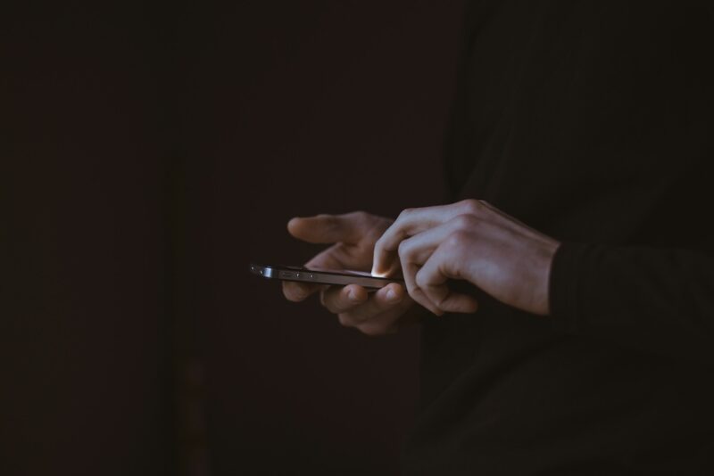 Man holding a cellphone in the dark.