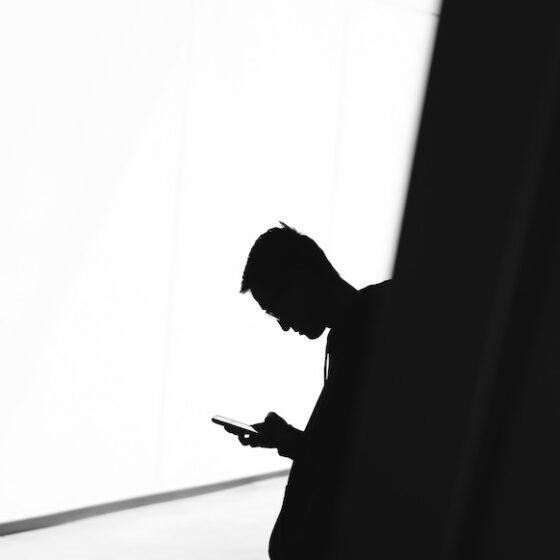 Silhouette of a man on his cell phone.