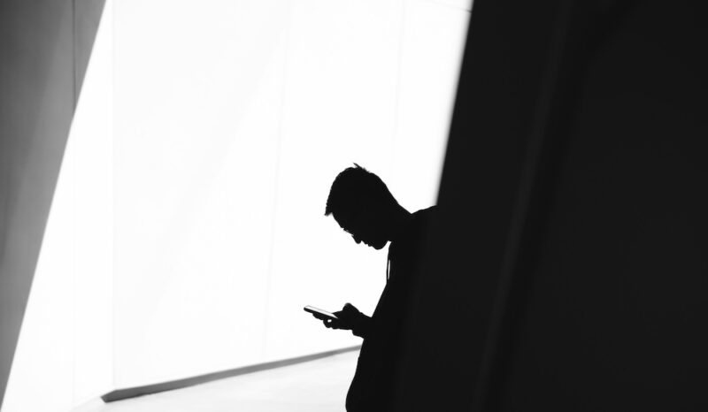 Silhouette of a man on his cell phone.