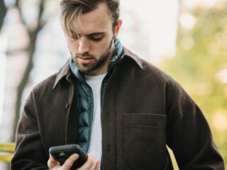 Man using cell phone in a park.