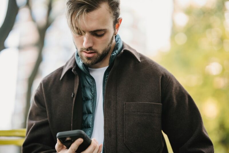 Man using cell phone in a park.