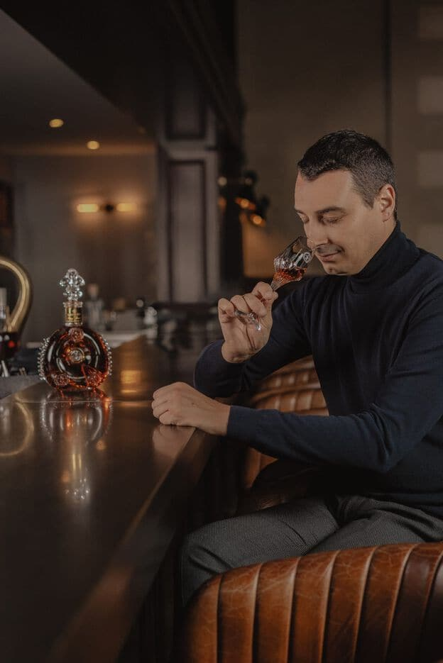 Louis XIII bottle decanter alongside next to youngest cellar master of the Remy Martin cellar master dynasty, Baptiste Loiseau