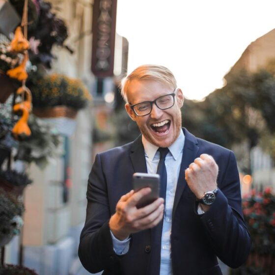 Man on cell phone cheering.