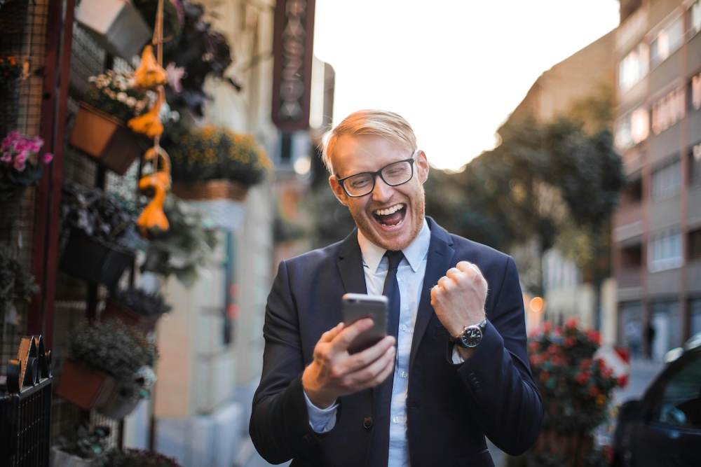 Man on cell phone cheering.