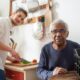 Guy cooking dinner for elderly gentlemen.